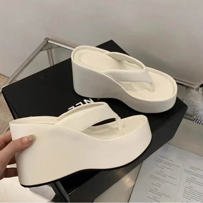 white-flip-flops-with-wedge-heel-holding
