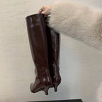 woman-holding-brown-kitten-heeled-knee-high-boots
